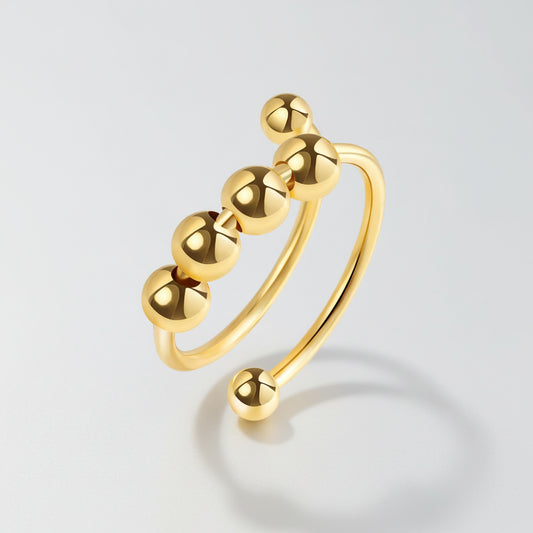 Gold ring with five spherical beads on a white background