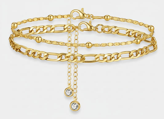 Gold chain bracelet with a central cross pendant on a white background