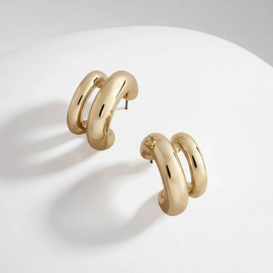 Gold hoop earrings on a light background