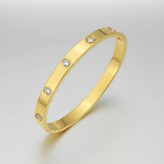 Gold bracelet with embedded diamonds on a white background